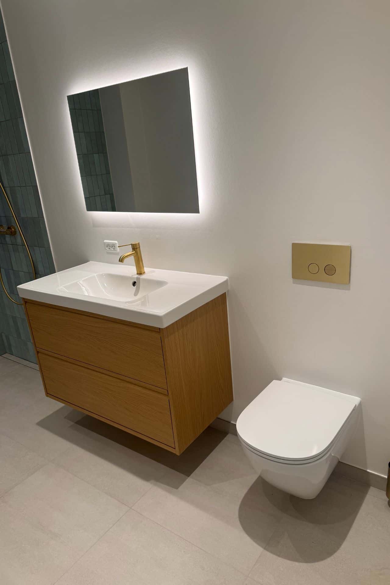 Modernisering af badeværelse med væghængt toilet og vaskeskab i træ udført af Mauritzen Gruppen