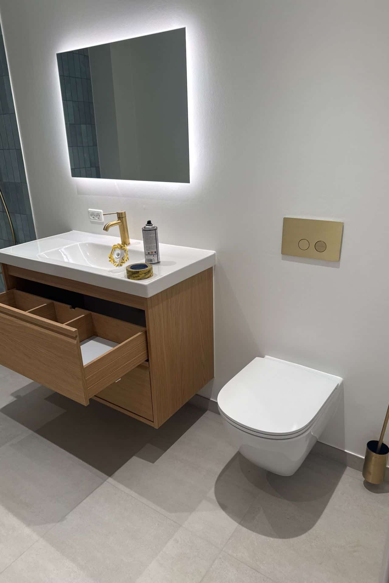Montering af badeværelsesmøbel med åben skuffe og væghængt toilet udført af Mauritzen Gruppen